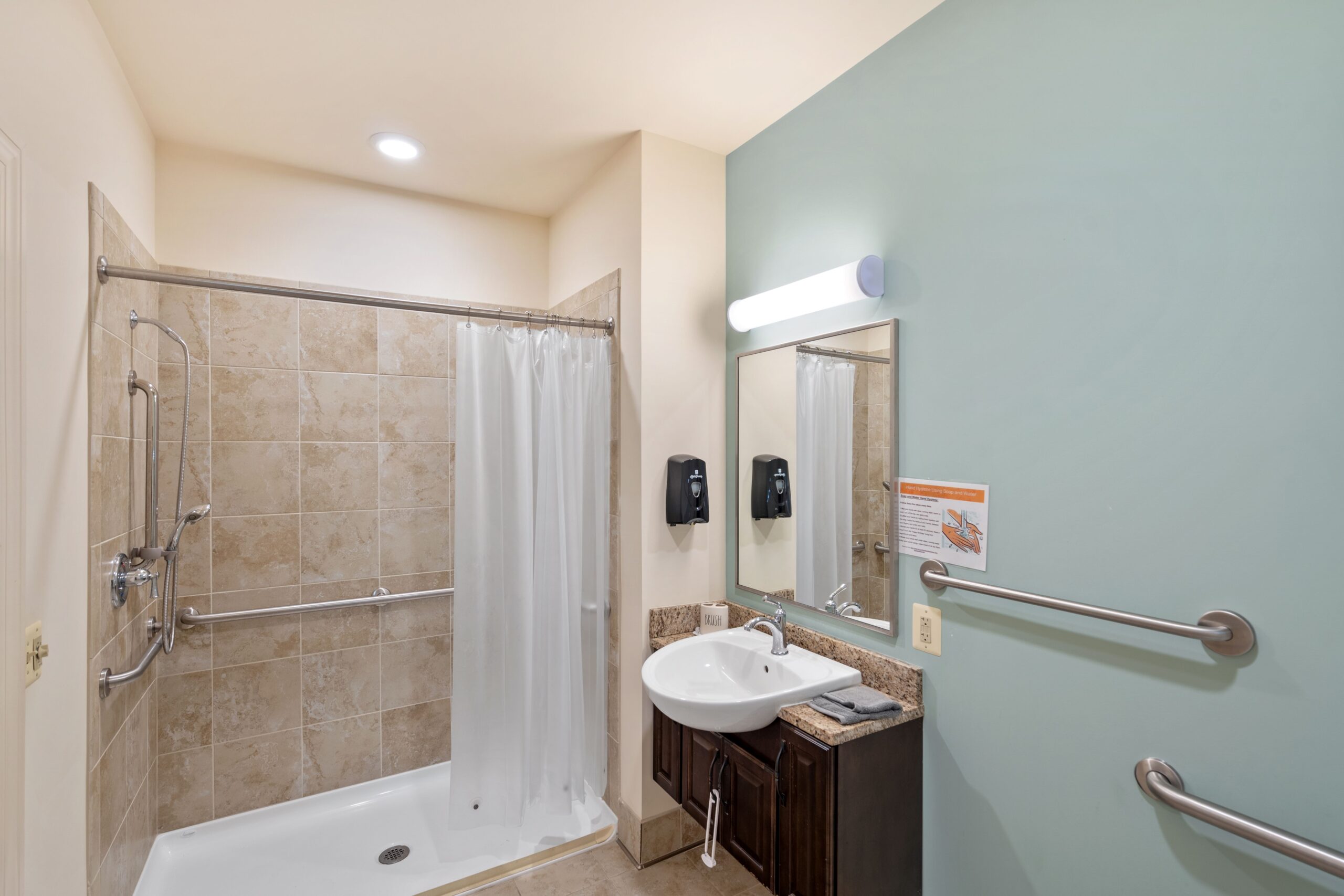 Bathroom with walk-in shower and hand rails